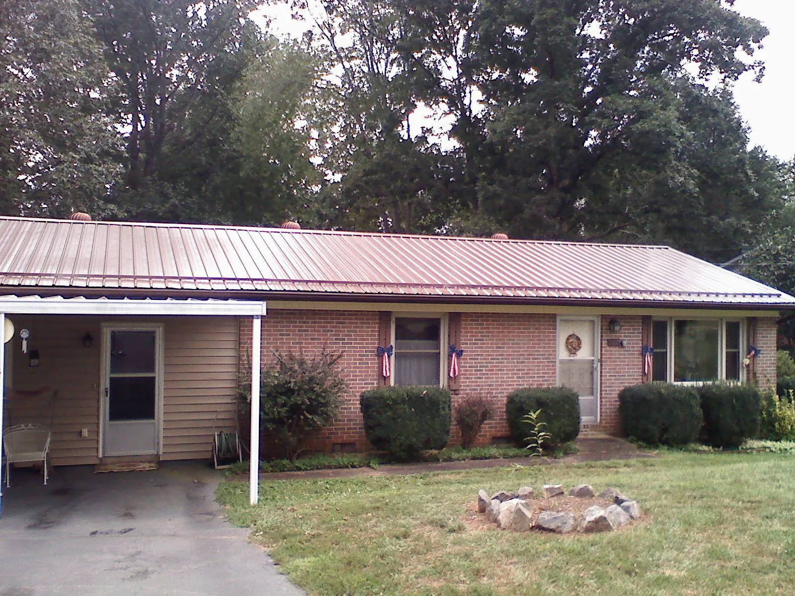 Bronze metal roof and carport on a brick ranch home — Roof Repair work by our crew in Servia